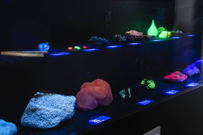 Fluoreszierende Minerale im Museum Wiesbaden. Werden Mineralen mit UV-Licht bestrahlt, leuchten einige von ihnen in mehr oder weniger hellen Farben auf. Dieser Effekt konnte erstmals am Mineral Fluorit gezeigt werden und wird daher als Fluoreszenz bezeich