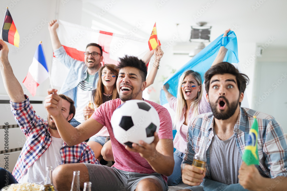 Jubelnde Fußball Freunde schauen ein Spiel auf dem TV 